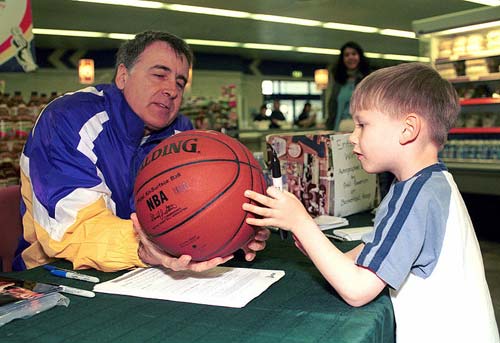 Goodrich (left) autographing a basketball in 2001.